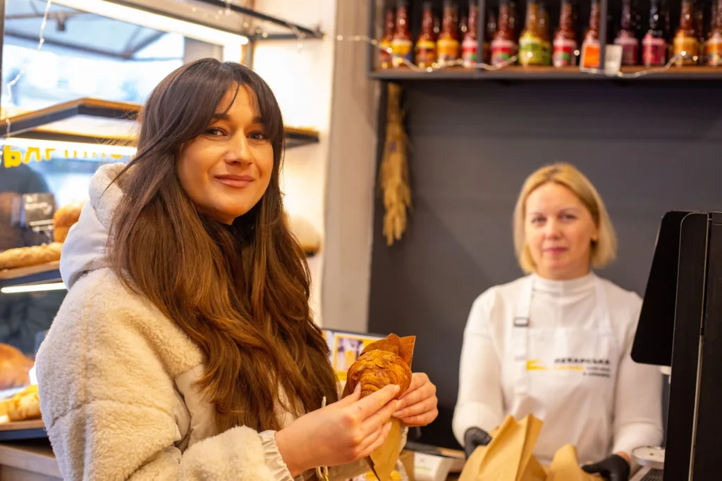 Жінка купує круасан у пекарні