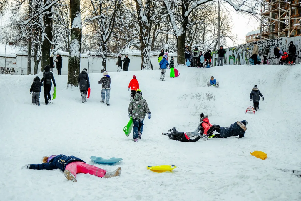 Діти катаються на санках зі снігової гірки