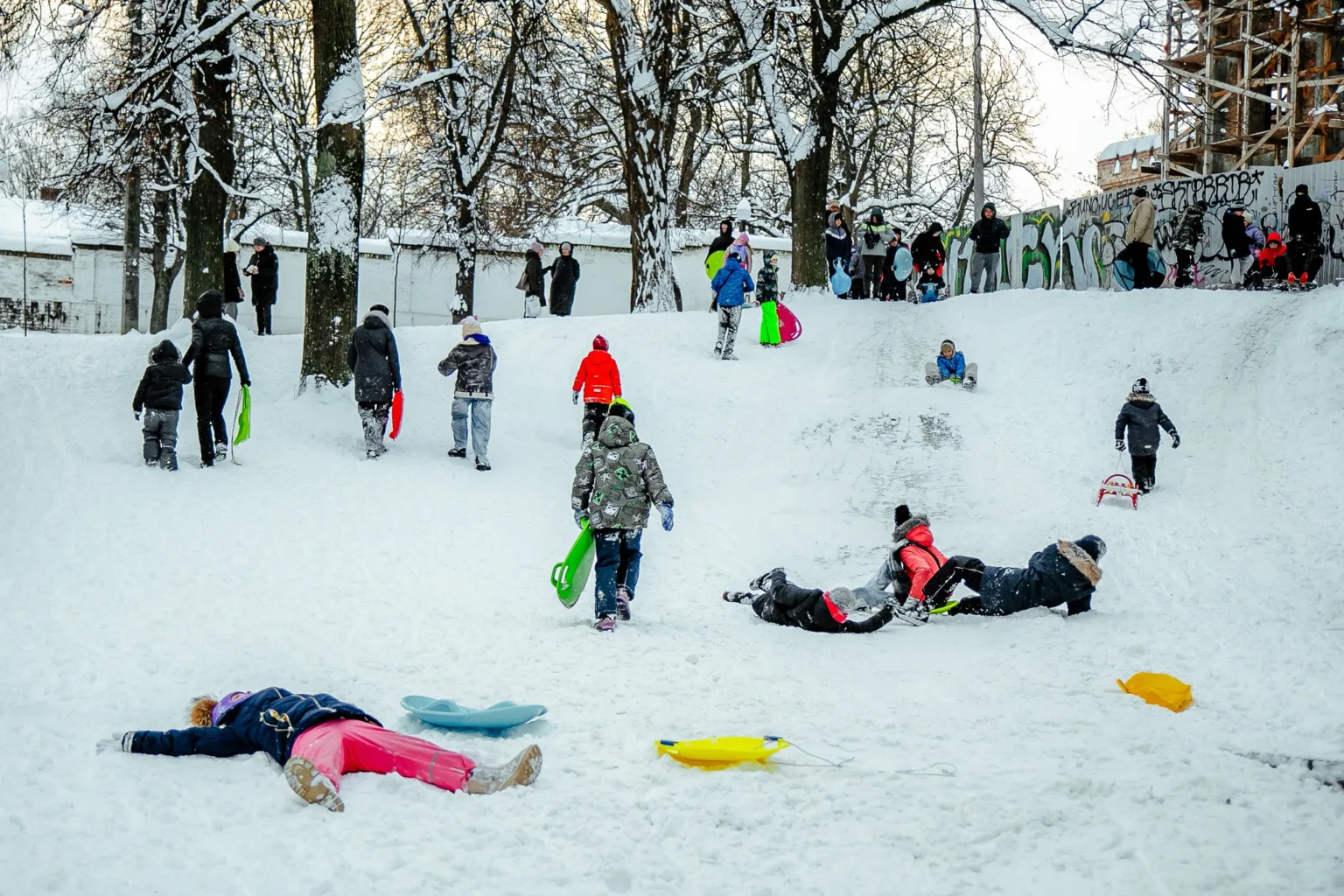 Діти катаються на санках зі снігової гірки