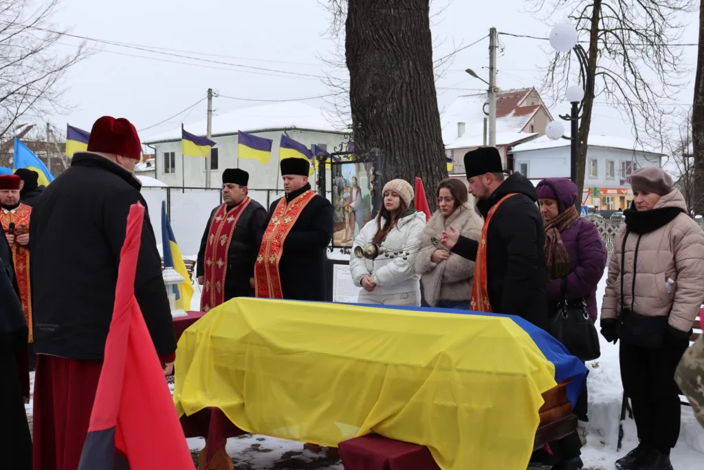 Поминальна церемонія з труною, вкритою прапором України