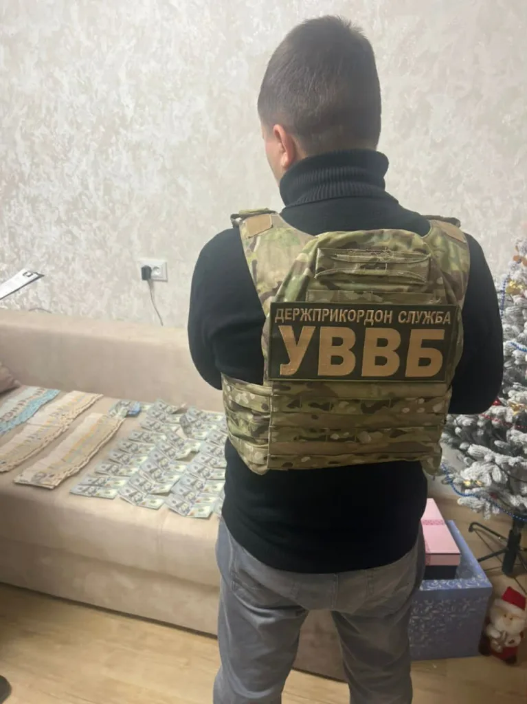 Співробітник ДПСУ з грошима на столі