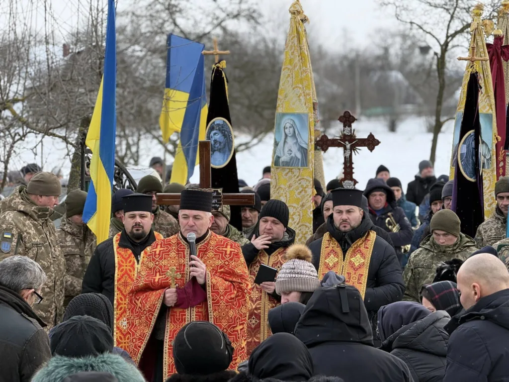 Священники та військові на похоронній церемонії взимку
