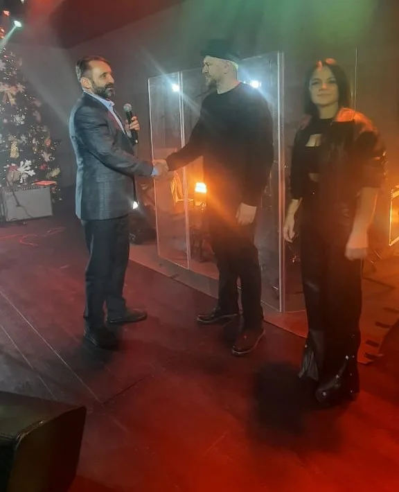 Люди вітаються на сцені під час заходу