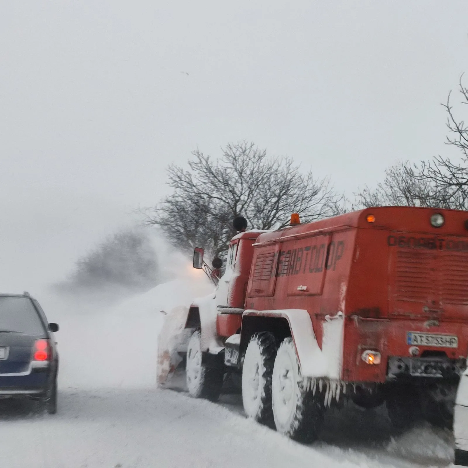 Снігоочисник прибирає заметену зимову дорогу
