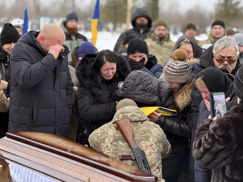 Люди оплакують загиблого військового біля труни