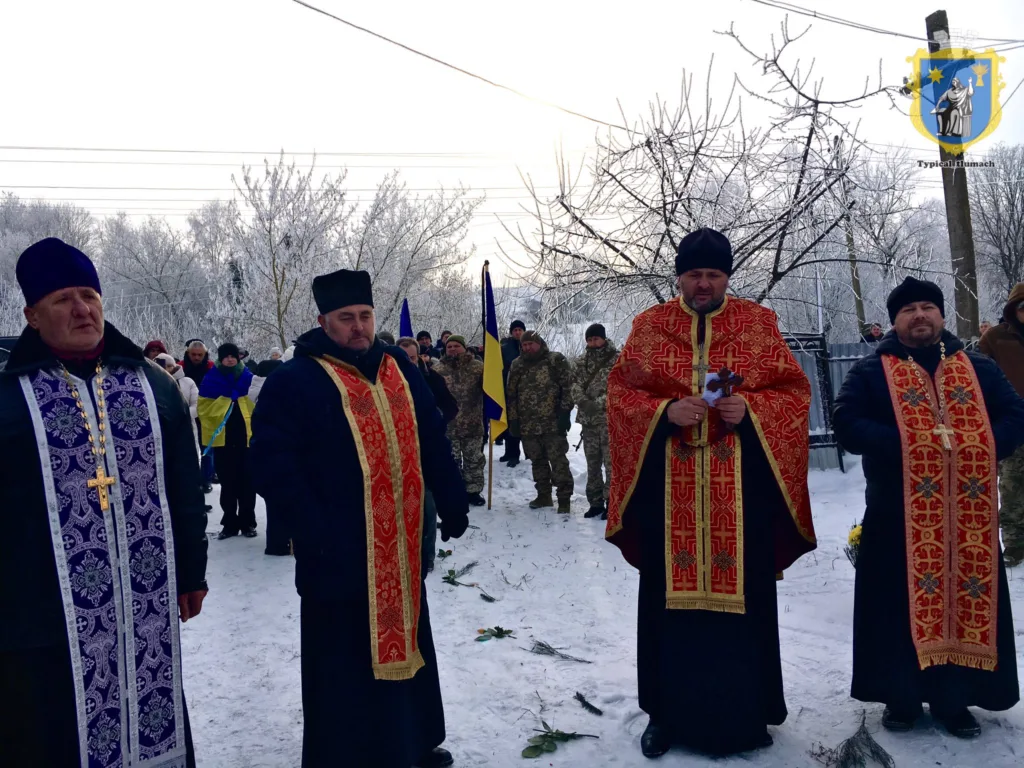 Священники на зимній церемонії з українськими прапорами