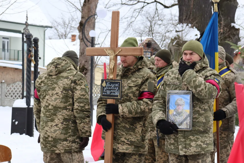 Військові несуть хрест і фото загиблого солдата
