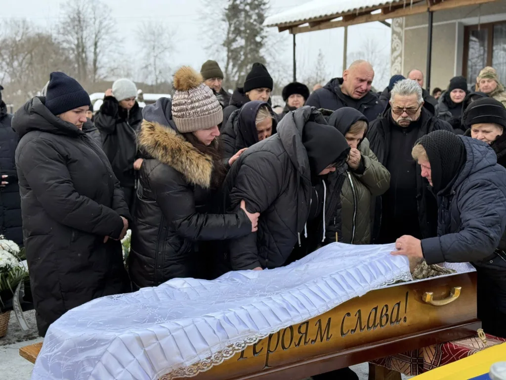 Люди прощаються з військовим героєм на похороні