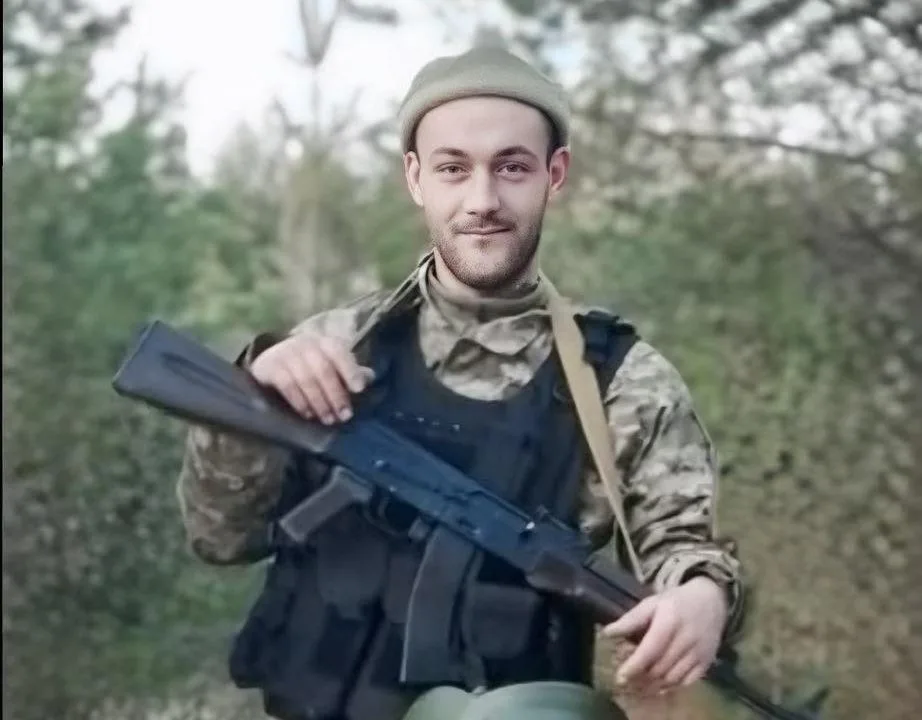 Військовий у формі тримає зброю в лісі