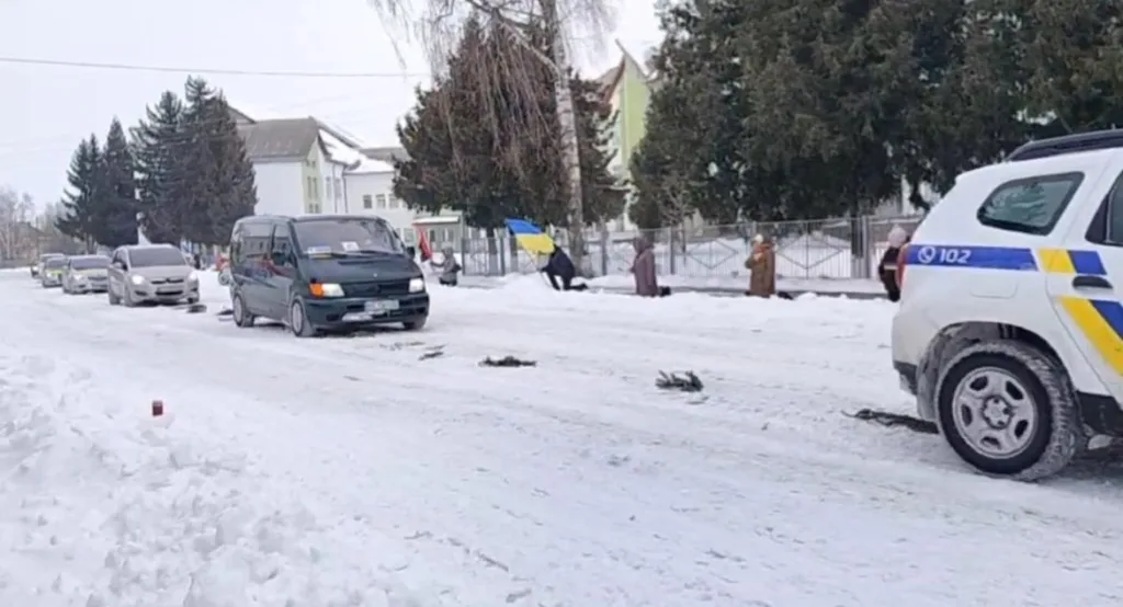 Автоколона на засніженій дорозі з поліцейським авто