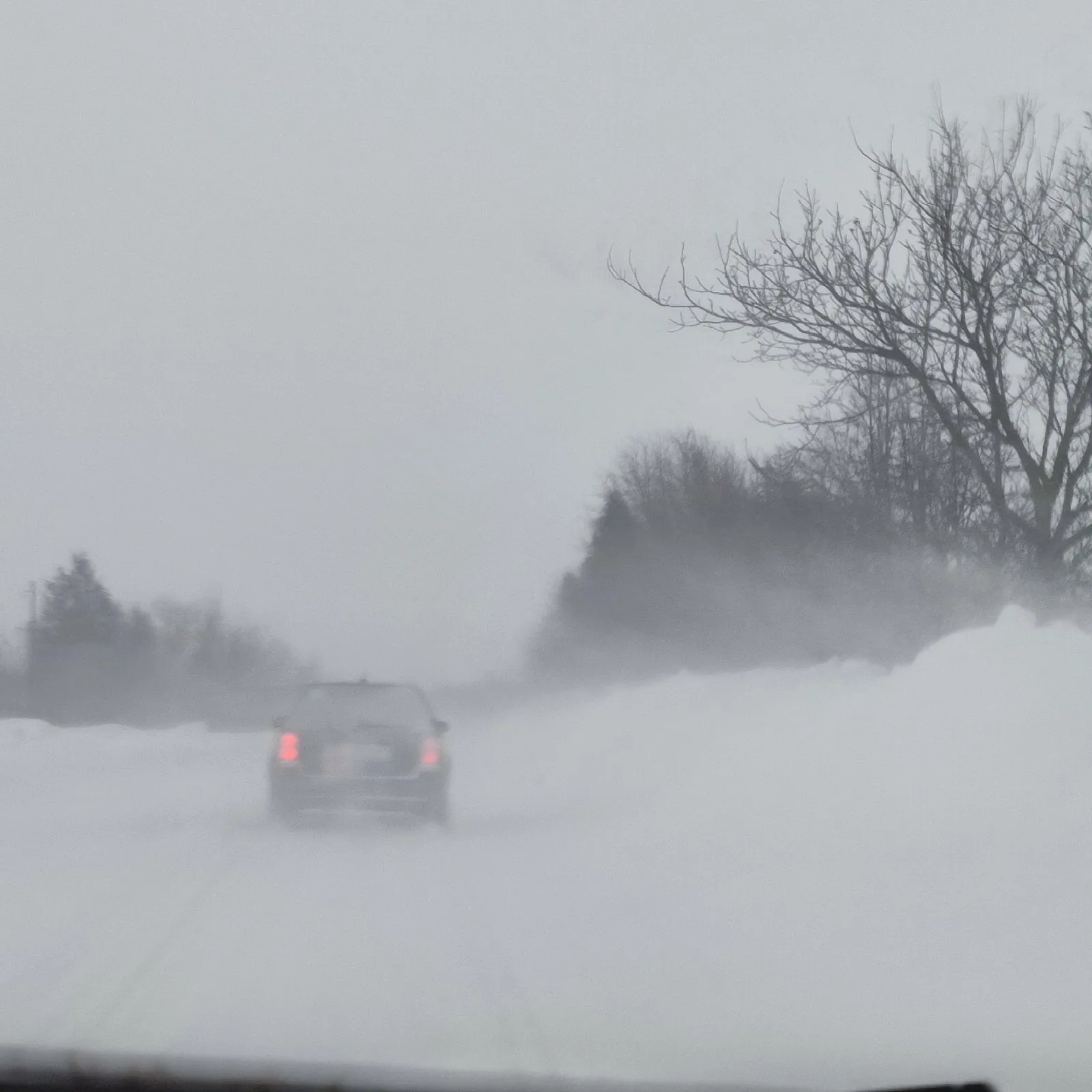 Автомобіль їде засніженою зимовою дорогою в заметіль