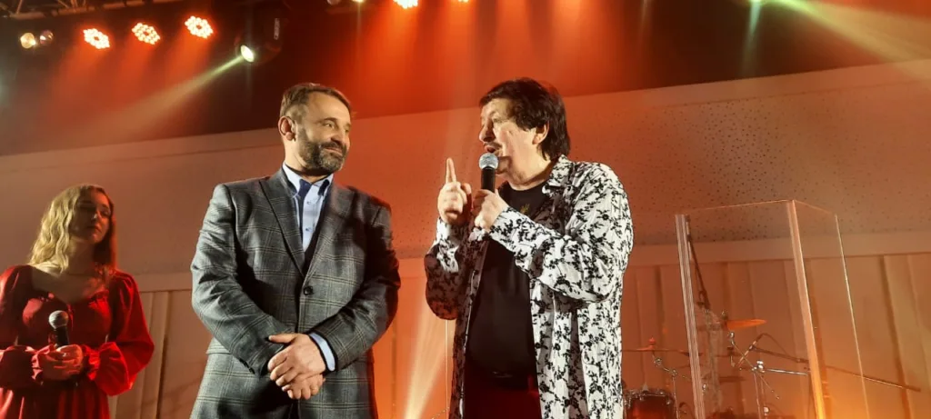 Люди спілкуються на сцені під концертним освітленням