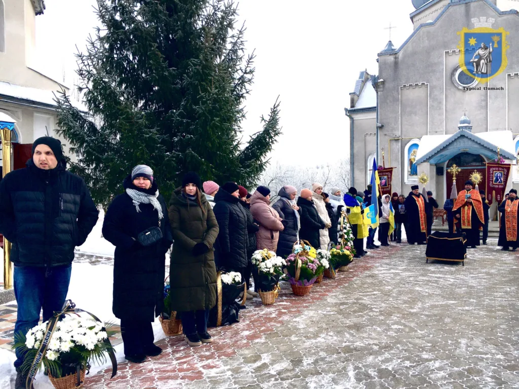 Люди на церемонії біля церкви взимку