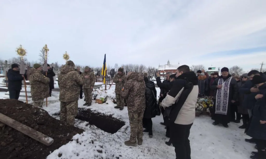 Похорон військового взимку з українським прапором