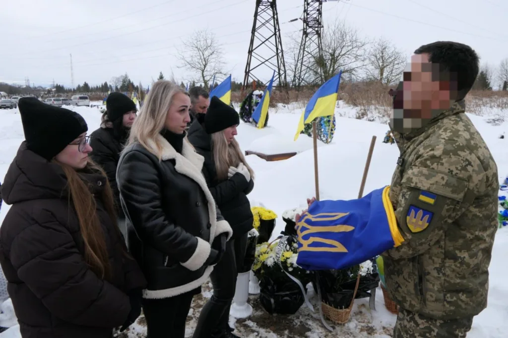 Вшанування загиблого військового з українським прапором