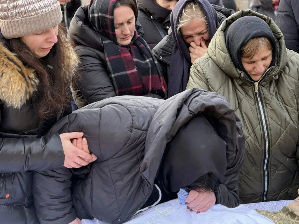 Люди оплакують близьку людину на похороні