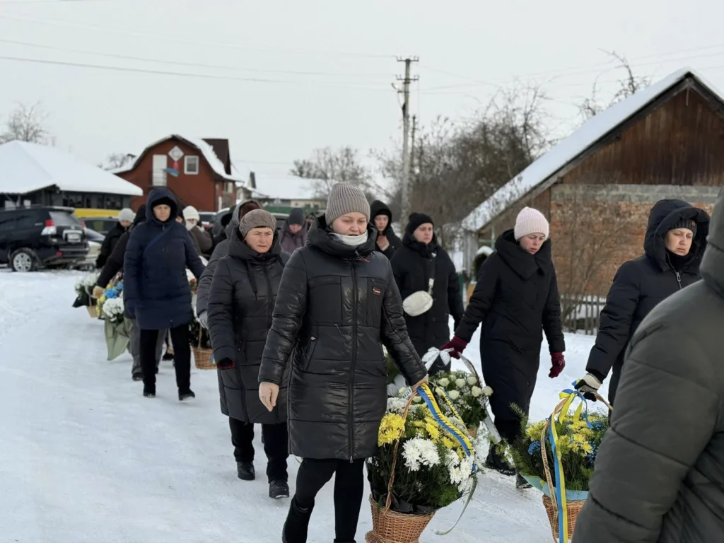 Люди несуть квіти на зимовій вулиці