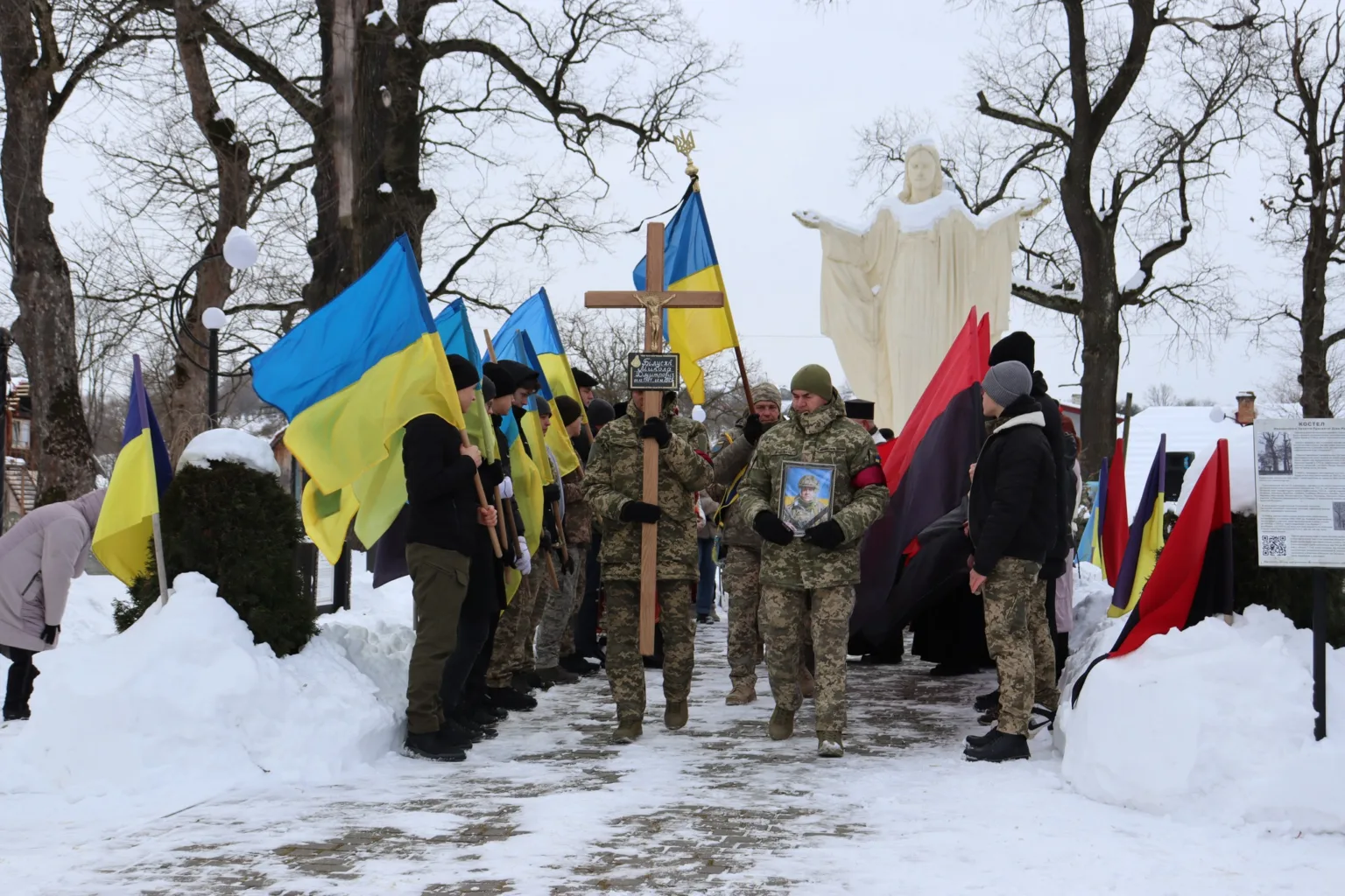 Військовий похорон із українськими прапорами взимку
