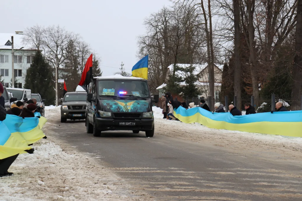 Люди тримають великий український прапор на вулиці