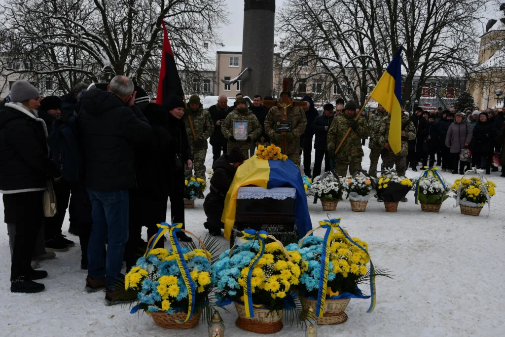 Поховання українського військового взимку з прапором України