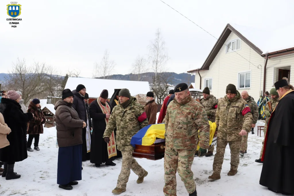 Військові несуть труну, люди проводжають героя