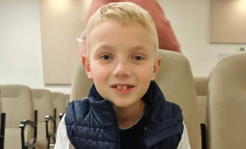 Хлопчик сидить у залі на кріслі