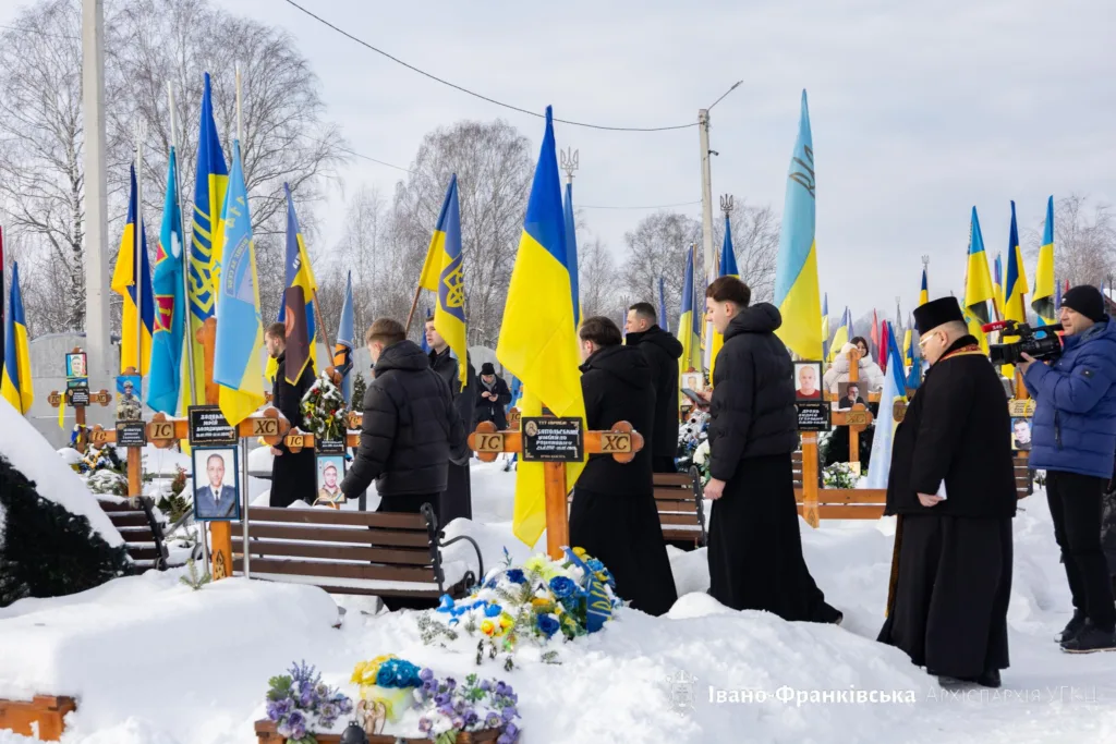 Поминальна церемонія на цвинтарі з українськими прапорами