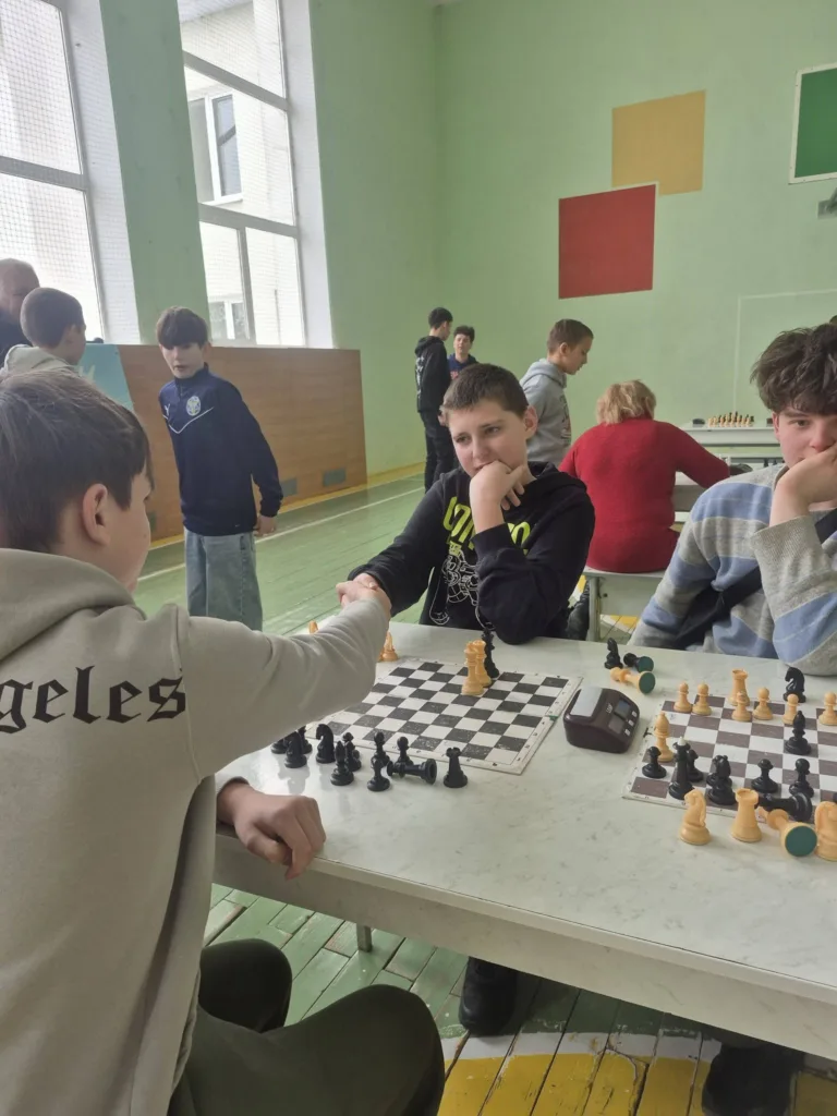 Учні грають у шахи в шкільному спортзалі