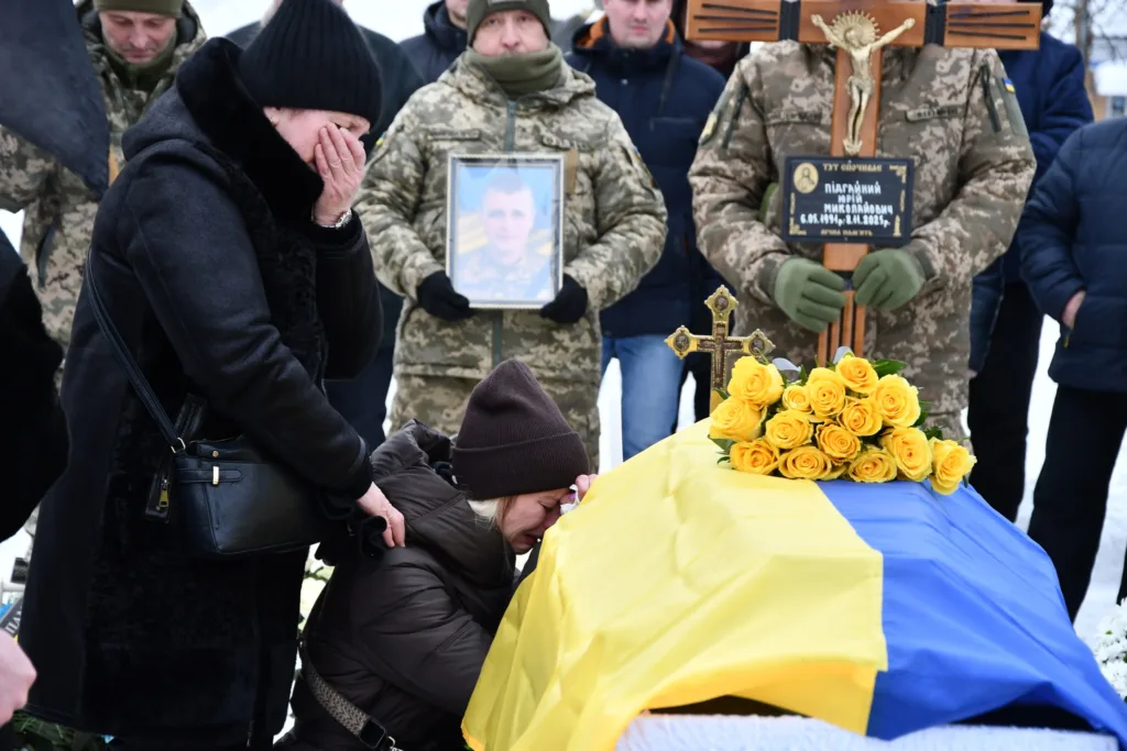 Похорон українського військового з прапором і квітами