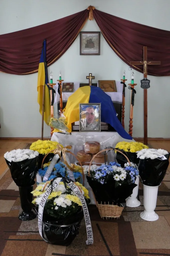 Похоронний вівтар з українським прапором і квітами