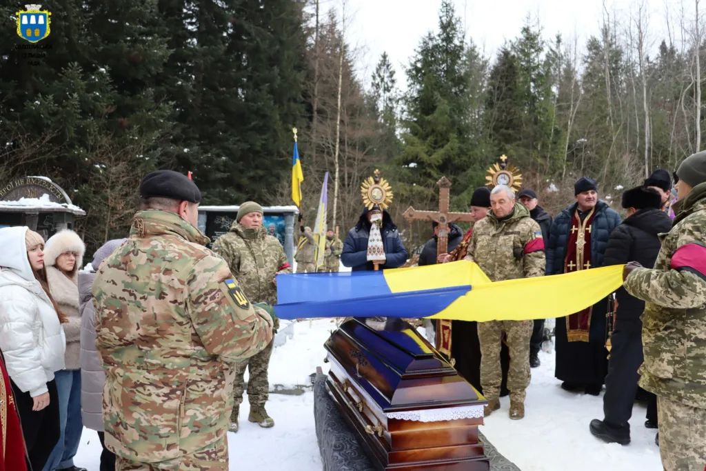 Військові проводжають героя з українським прапором