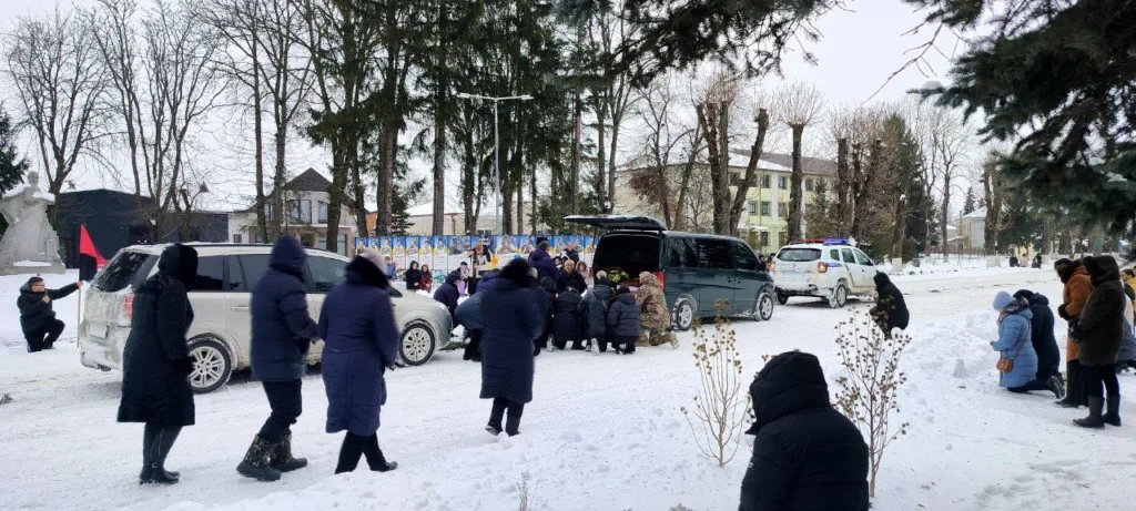Люди на колінах під час зимової церемонії