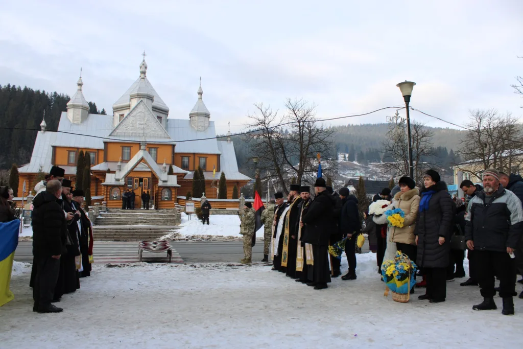 Люди з квітами біля церкви взимку