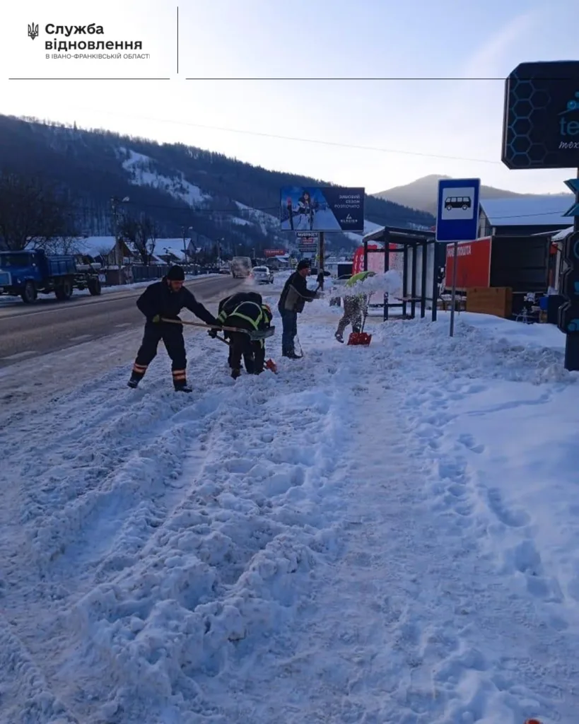 Працівники розчищають сніг біля автобусної зупинки