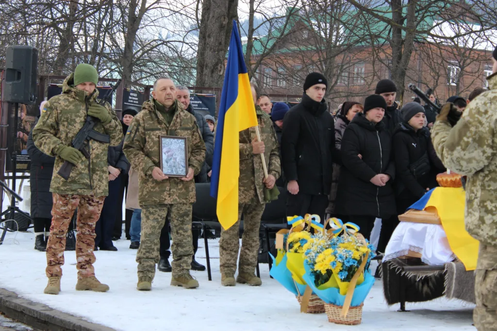 Вшанування загиблого військового з українським прапором