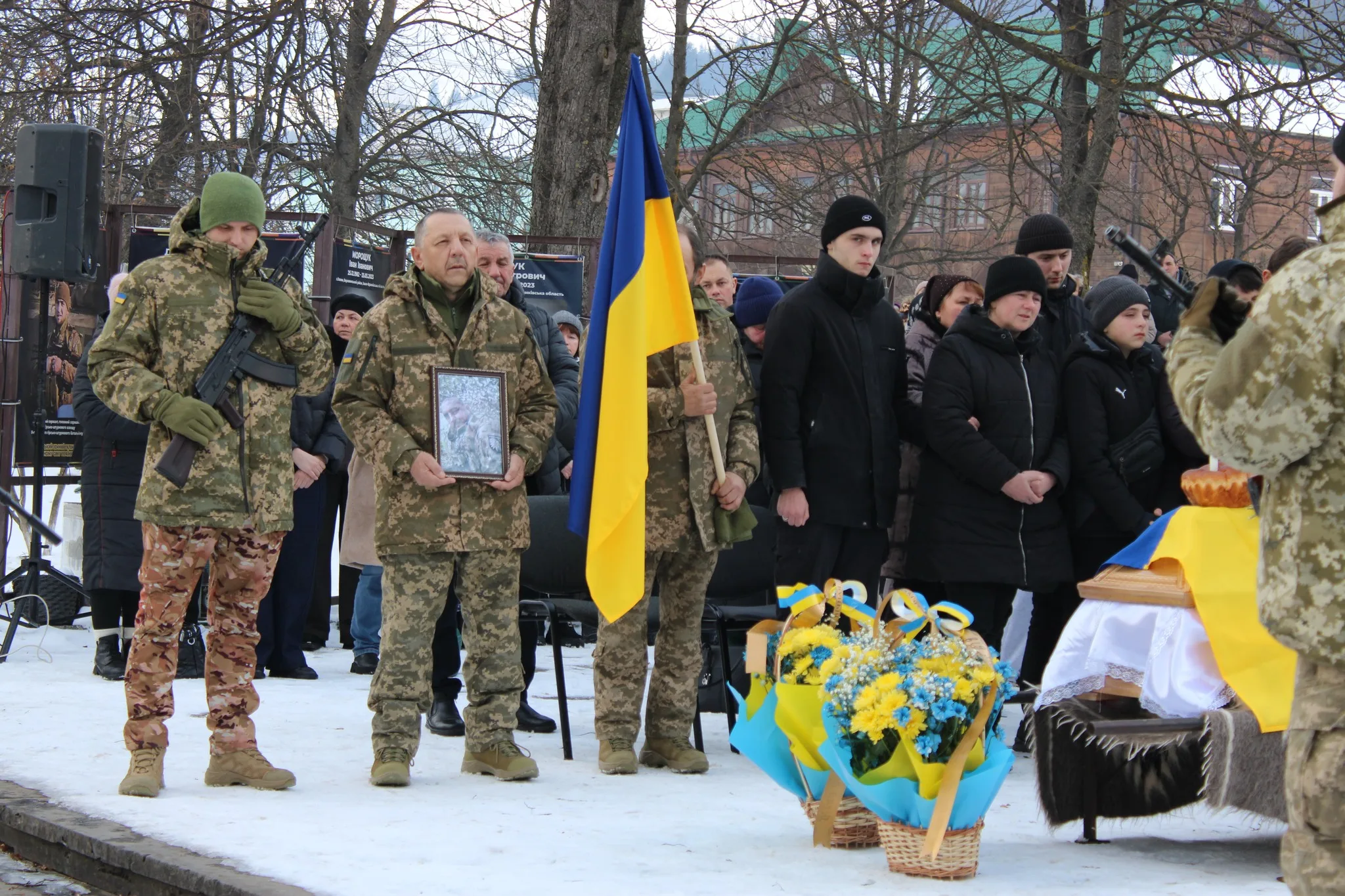 Вшанування загиблого військового з українським прапором