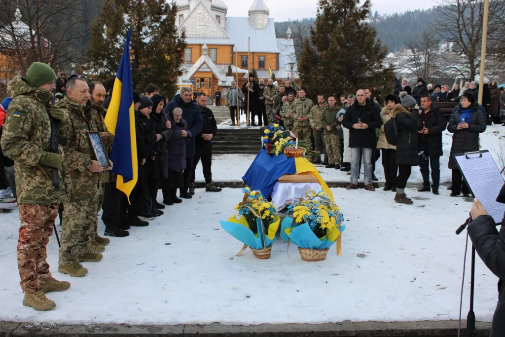 Похорон військового з українським прапором на снігу