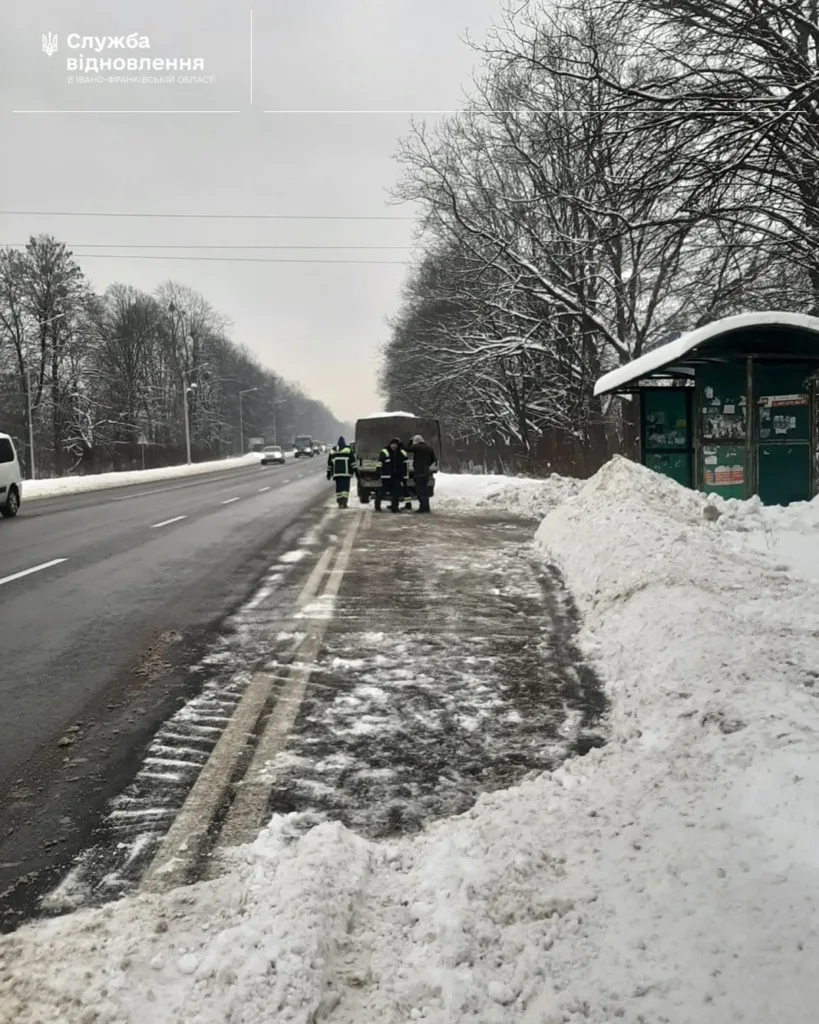 Робітники очищають автобусну зупинку від снігу