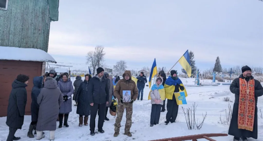 Люди на снігу з українськими прапорами