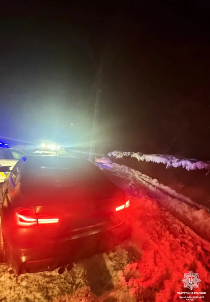 Поліцейське авто на засніженій дорозі вночі