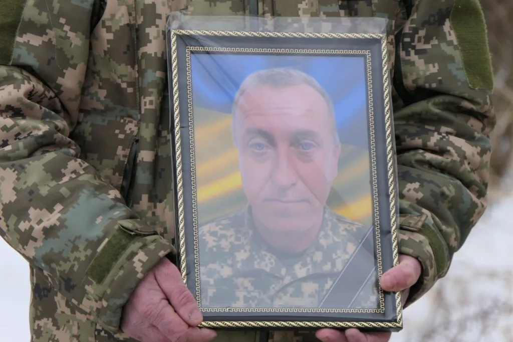Військовий тримає фото загиблого солдата України
