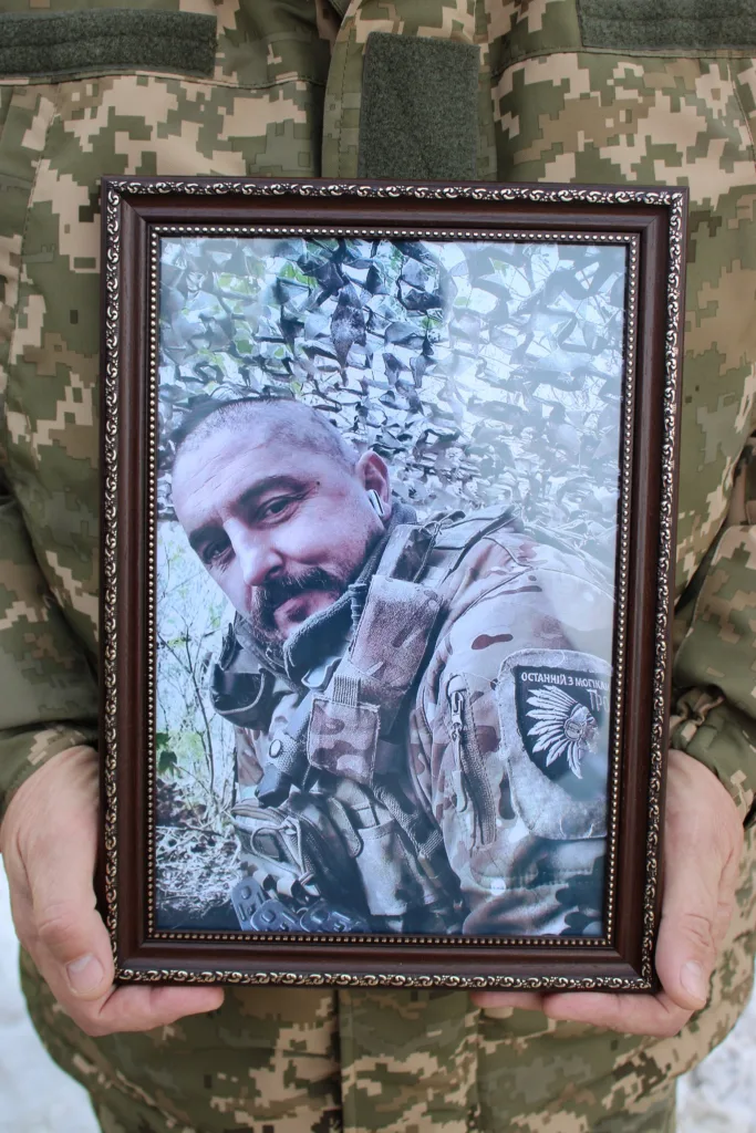 Військовий тримає фото солдата в рамці