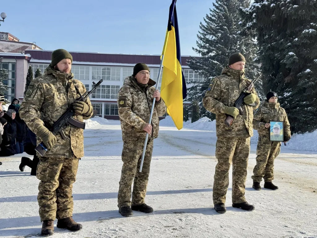 Українські військові тримають прапор на церемонії взимку
