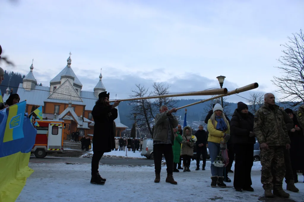 Люди з трембітами біля церкви в горах
