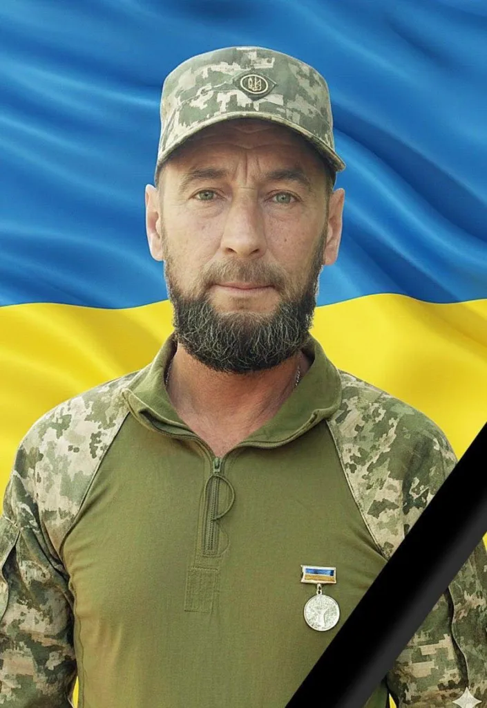 Український військовий на фоні прапора України