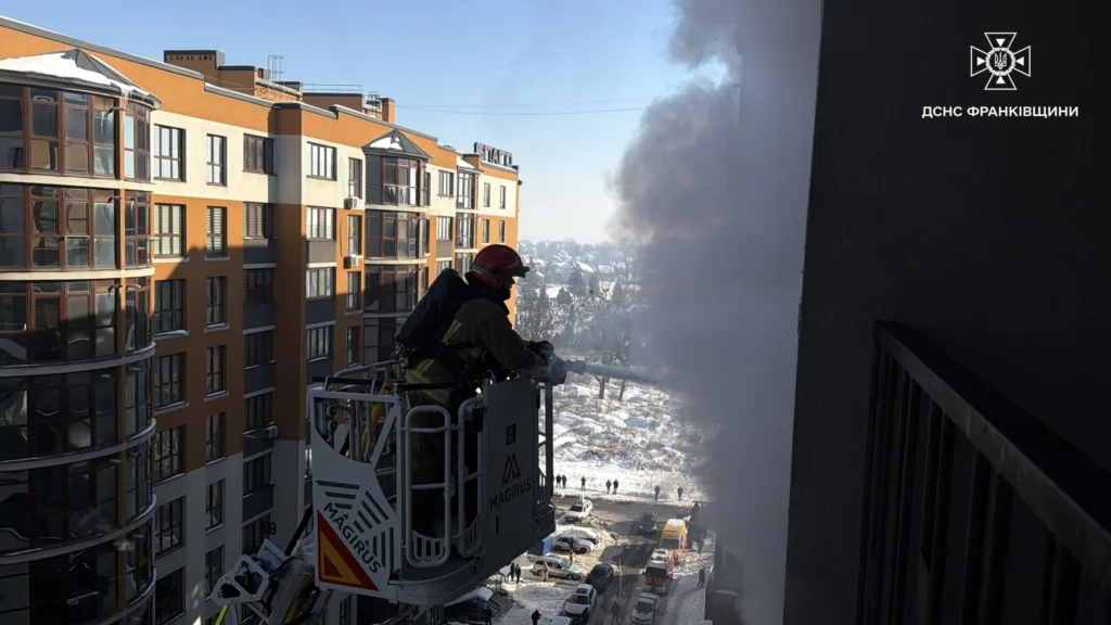 Пожежник гасить вогонь у багатоповерхівці