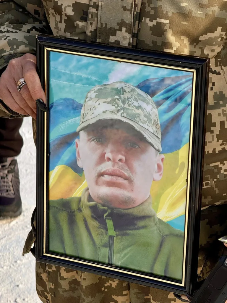 Фото українського військового у камуфляжі з прапором