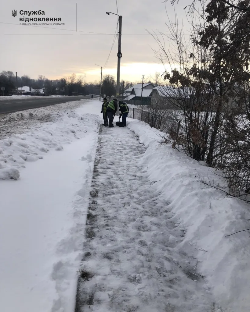 Робітники очищують тротуар від снігу взимку