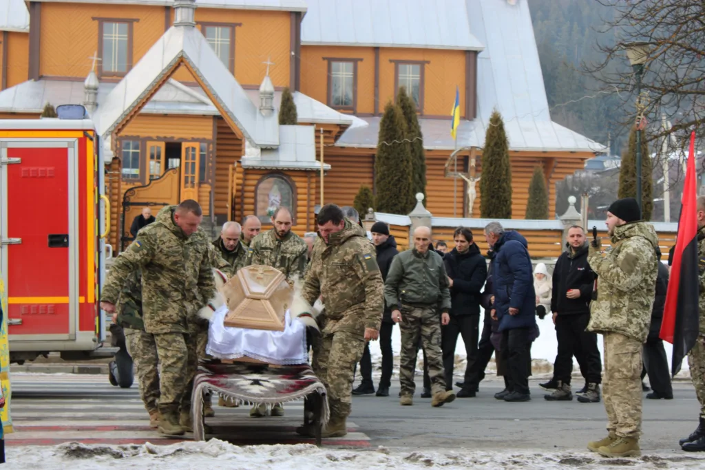Військові несуть труну перед церквою в Україні