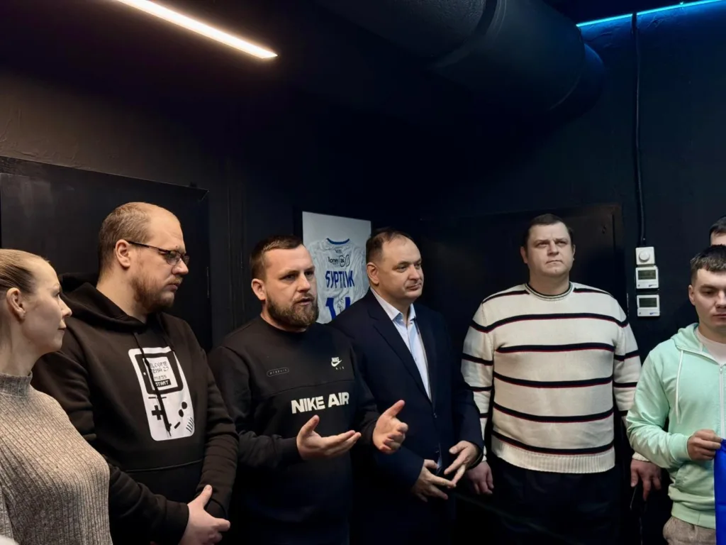 Група людей обговорює щось у сучасному приміщенні